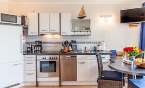 Departamento Confort, 2 habitaciones, Terraza, planta baja | Cocina privada | Refrigerador con congelador, lavavajillas y cafetera y tetera