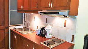 Une cuisine avec des meubles en bois, un évier en acier inoxydable, un four à micro-ondes et un grille-pain.