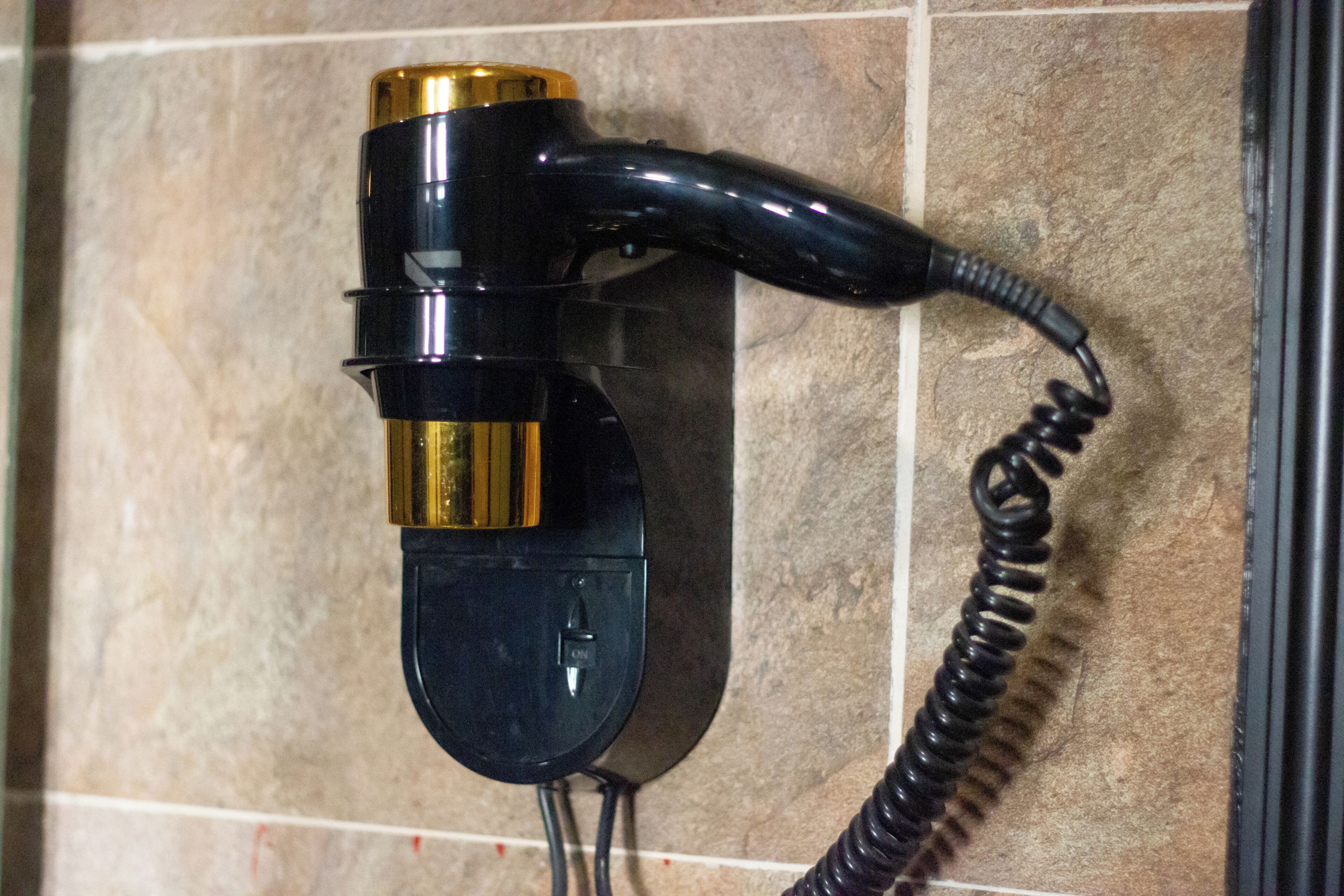 A wall-mounted telephone with a coiled cord.