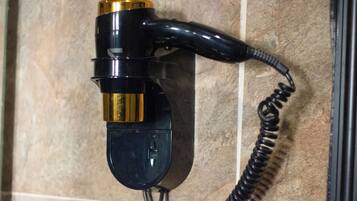 A wall-mounted telephone with a coiled cord.