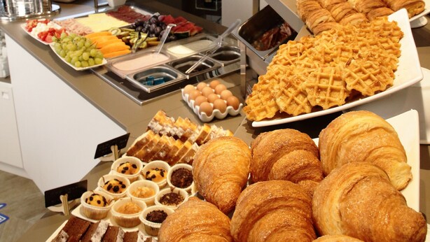 A buffet with various food items including pastries, fruits, and beverages. - Hotel Toledo (Jesolo)