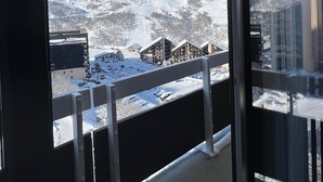 Ein Balkon mit Blick auf einen schneebedeckten Berg und eine Stadt darunter.