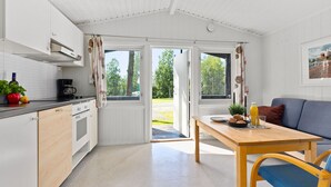 Een moderne keuken met witte kastjes, een houten eettafel en een blauwe stoel.