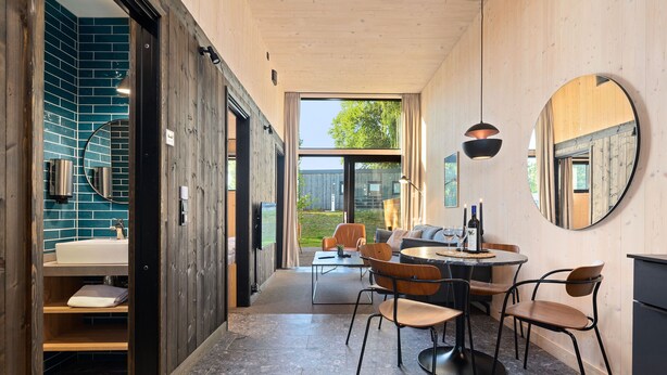 Een modern interieur met een badkamer, een eetgedeelte en grote ramen.