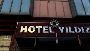 Un bâtiment d’hôtel avec une enseigne bien visible portant l’inscription « HÔTEL YILDIZ ».