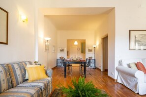 Un salon avec un canapé, une table à manger et un fauteuil blanc.