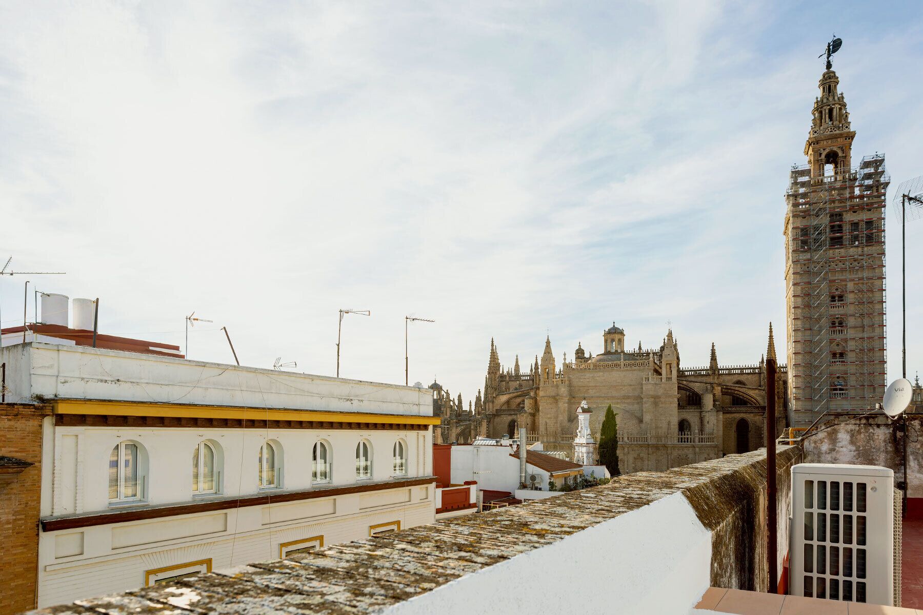 A historic building with a tall tower and a bridge in the background.