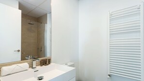 A modern bathroom with a white sink, mirror, and toilet. - Genteel Home Mateos Gago V (Seville)