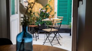 An outdoor patio with a table and chairs, a wooden fence, and a bamboo wall. - Affittacamere I Canneggiatori (Abbadia San Salvatore)