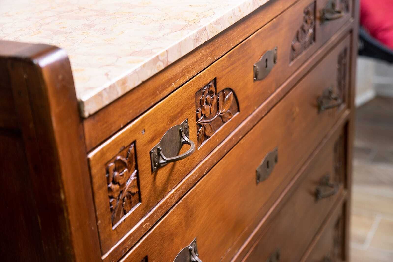A wooden dresser with drawers and a marble countertop.