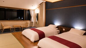 Une chambre d’hôtel avec deux lits, un bureau et une chaise.