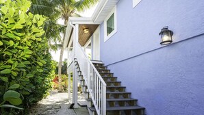 A staircase leading to a porch with a lantern on the wall. - Beachwalker Apartment:  Duplex within 100 steps to the sand. (Holmes Beach)