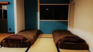A room with two single beds, a window, and a door. - The Sloope Nagasaki (Nagasaki)