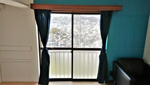 A room with a large window, a wooden ceiling beam, and a black chair. - The Sloope Nagasaki (Nagasaki)