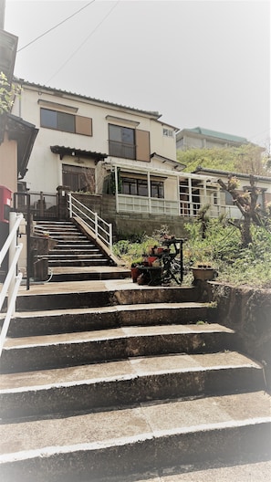 Edifício residencial com escadaria que leva a um portão.