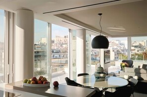 A modern dining area with a large window offering a city view. - Sunlight Acropolis Loft (Athens)