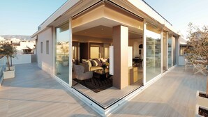 A modern house with a glass-enclosed living area, a balcony, and a view of the cityscape. - Sunlight Acropolis Loft (Athens)