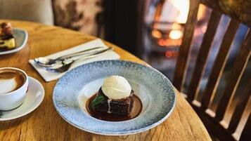 A dessert plate with a scoop of ice cream and a piece of cake on a wooden table.