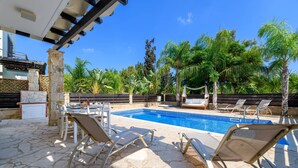 Ein Poolbereich mit Liegestühlen und einer Steinterrasse.