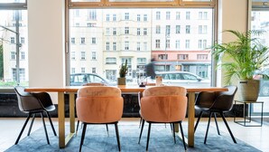 Un espace repas moderne avec une grande fenêtre, une table et quatre chaises.