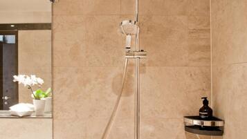 A modern bathroom with a shower, a sink, and a mirror.