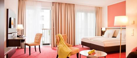 Una habitación de hotel con cama, escritorio, silla, sofá y una mesita.
