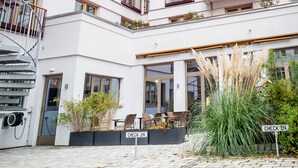 Un hôtel à plusieurs étages doté d’un escalier en colimaçon, de balcons et d’un espace extérieur aménagé pour s’asseoir.