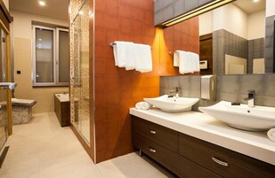 Un baño moderno con dos lavamanos, un espejo grande y una zona de ducha.