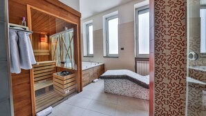 A modern bathroom with a wooden vanity, a glass shower enclosure, and a patterned shower curtain. - Atera Business Suites (Belgrade)