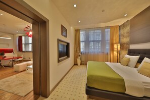 Relax in a stylish room with a large bed, flat-screen TV, and cozy seating area.