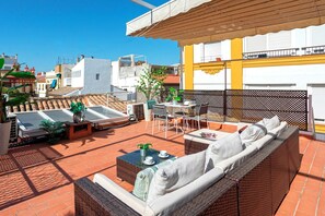 A rooftop patio with outdoor furniture, a table, and potted plants. - Genteel Home Puerta Real (Seville)