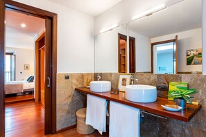 A modern bathroom with two sinks, a large mirror, and a wooden vanity. - Genteel Home Puerta Real (Seville)