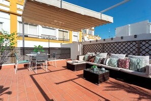 An outdoor patio with a sofa, chairs, and a table. - Genteel Home Puerta Real (Seville)