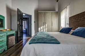 A bedroom with a bed, a dresser, and a wardrobe.