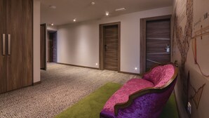 Un interior moderno con un sofá morado mullido, una alfombra verde y un armario de madera.
