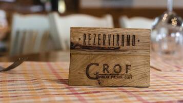 Un letrero de madera con la leyenda "REZERVANNO" y "GROF" sobre un mantel.