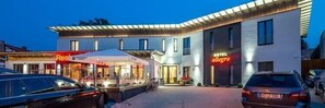 A hotel with a modern design, featuring a covered outdoor seating area and a well-lit entrance. - Hotel Allegro (Halberstadt)