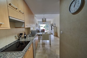 A modern kitchen with granite countertops, wooden cabinets, and a central island.