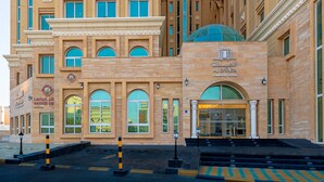 A hotel with a prominent entrance, large windows, and a dome structure. - Al Diyafa Furnished Suites (Doha)