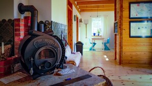 Un intérieur rustique avec un grand poêle à bois, une carte accrochée au mur et un coin salon confortable.