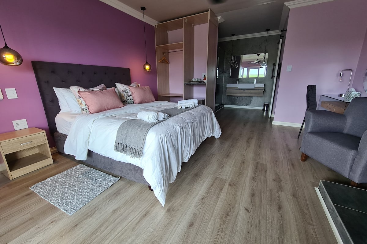 A bedroom with a bed, bedside table, and a dresser.
