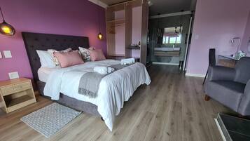 A bedroom with a bed, bedside table, and a dresser.