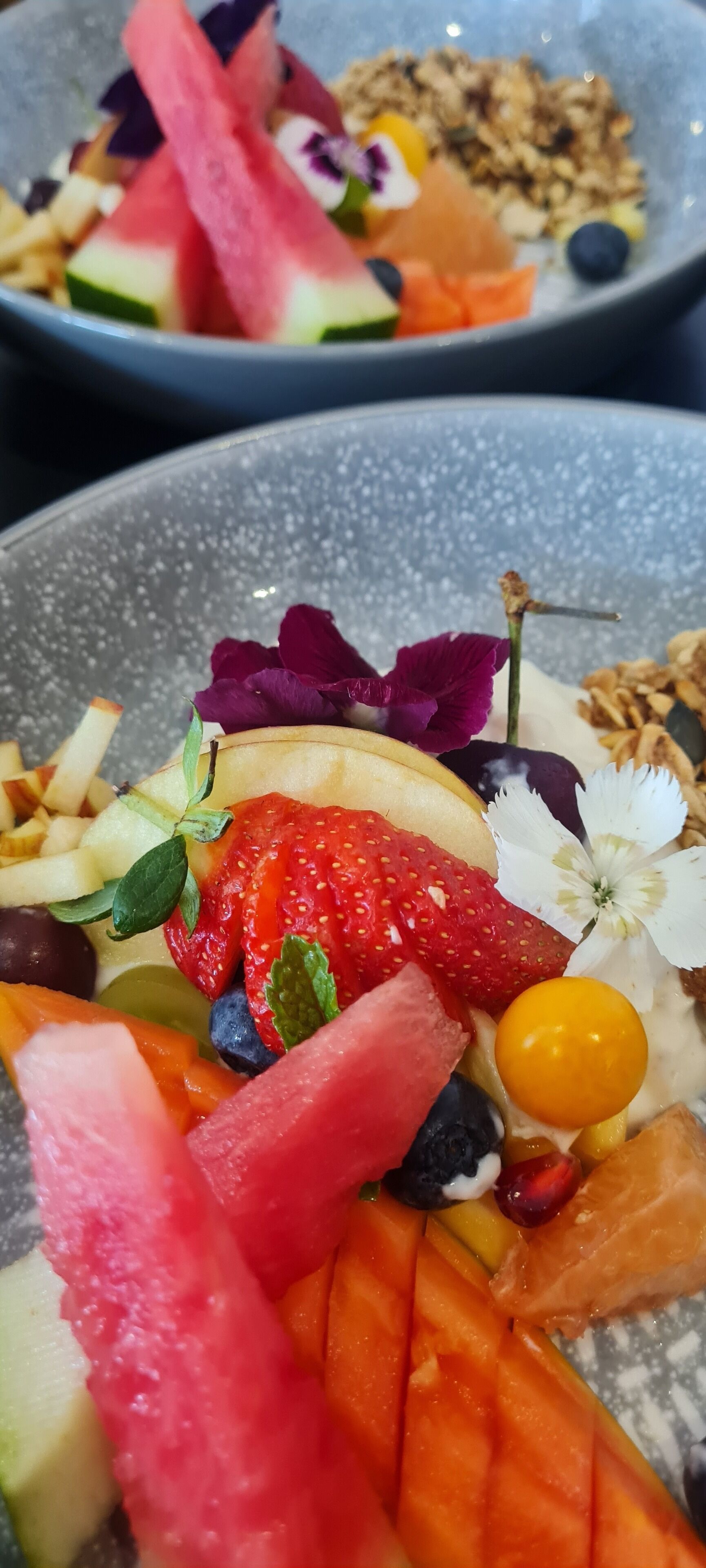 A close-up of a fruit and nut salad with various fruits and nuts.