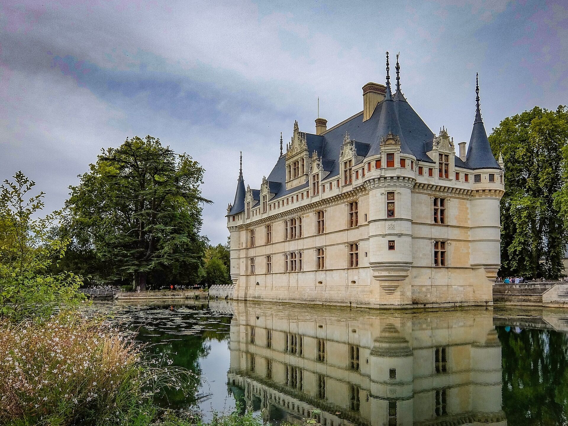 Un grand bâtiment historique doté de plusieurs tours et entouré de douves.