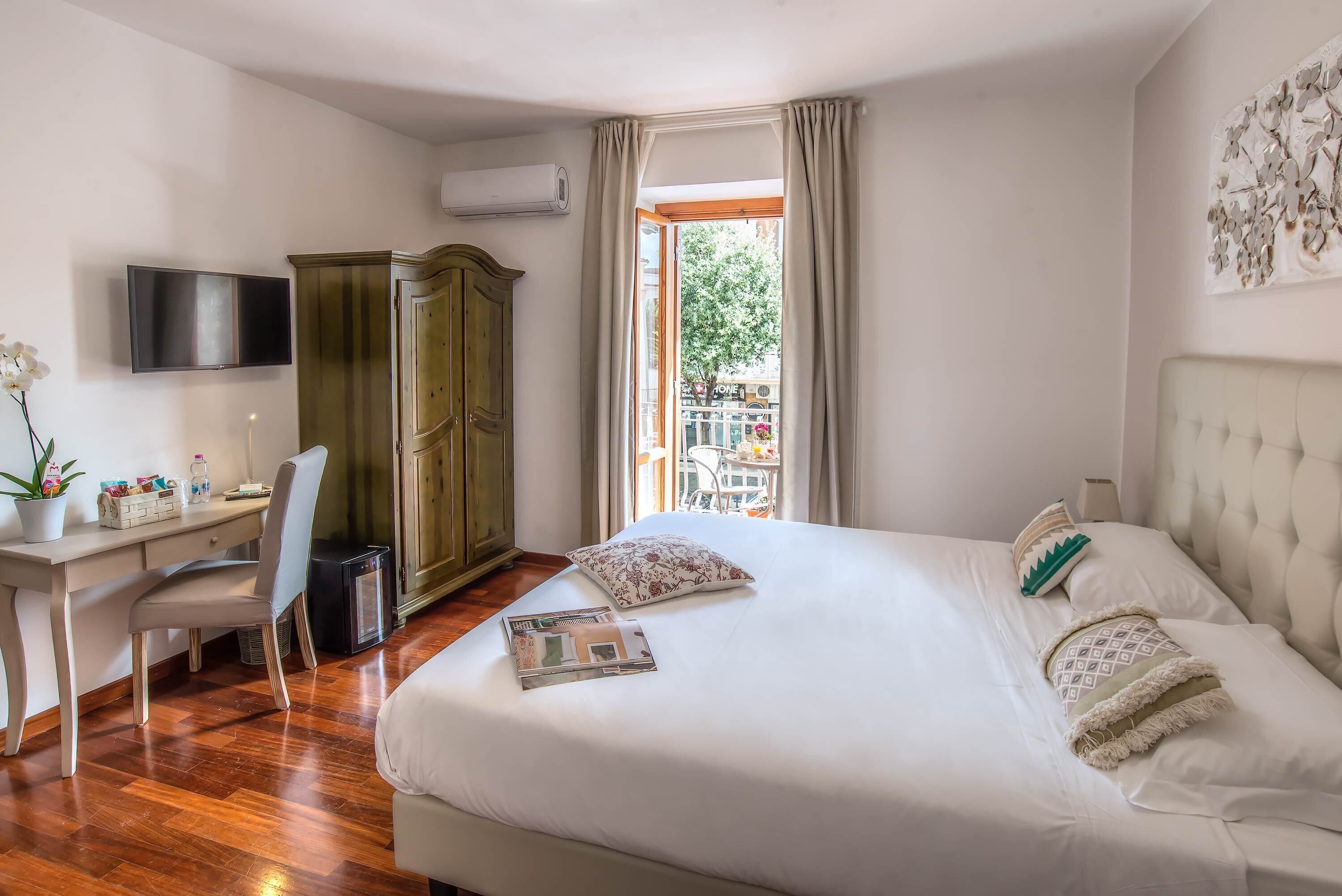 Un dormitorio con cama, escritorio, silla, armario y televisor.