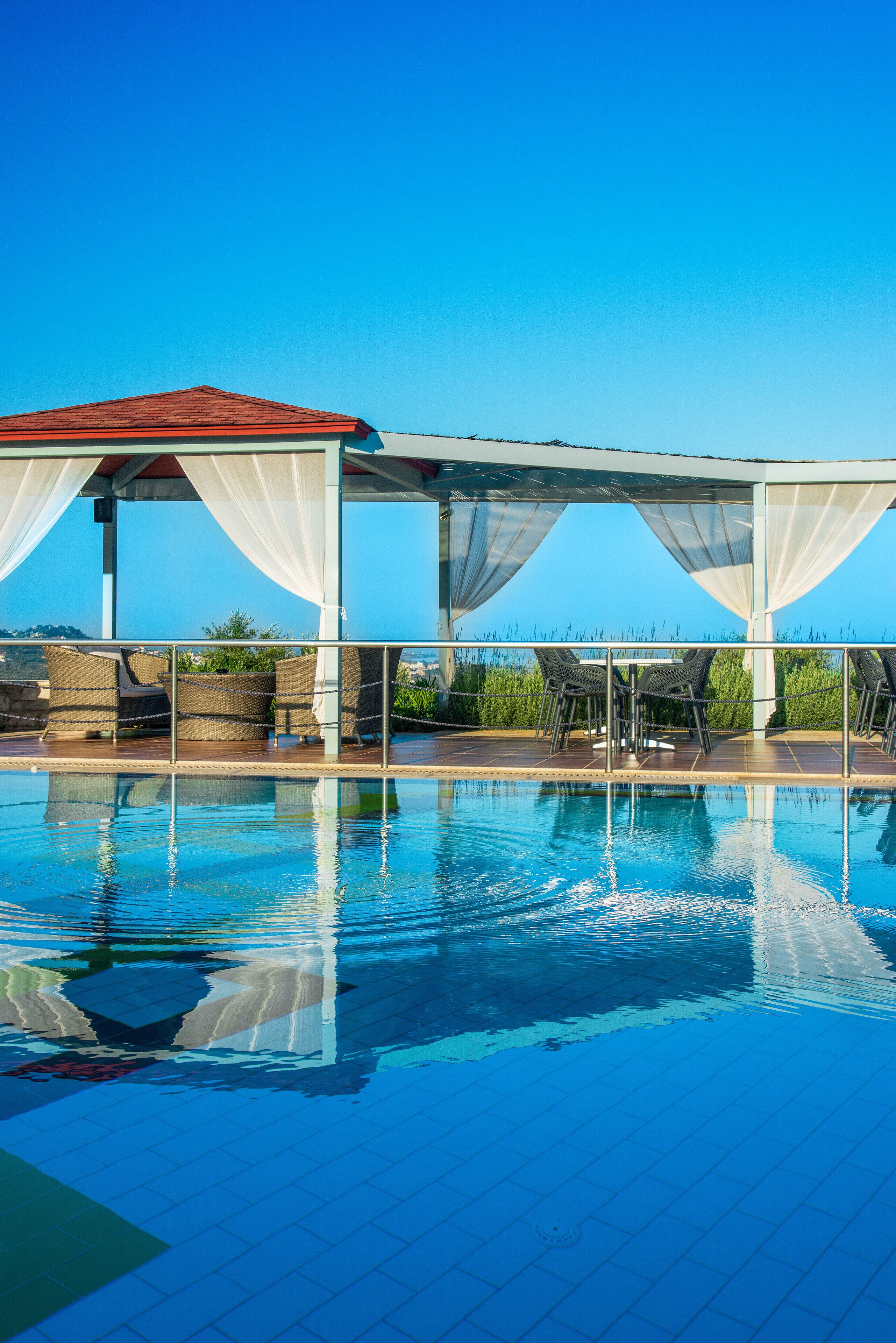 Una piscina al aire libre de temporada, sombrillas