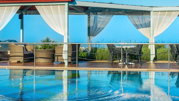 A pool area with a covered seating area and a view of the ocean. - Enastron Villas (Trifylia)