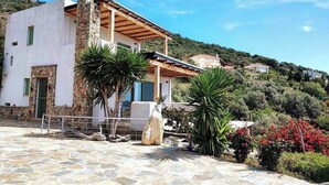 A modern two-story house with a stone facade, a wooden pergola, and a stone patio. - Seagulls - Within walking distance from sea! (Agioi Apostoloi)