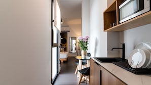 Una cocina pequeña con mostrador de madera, un microondas y un florero con flores.