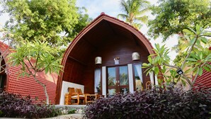 A wooden cabin with a sloped roof, large glass doors, and a small porch with seating. - Jungle Paradise (Penida Island)